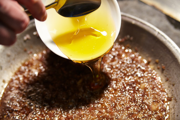 3.Добавить 50—70 мл бальзамического уксуса. Выпарить большую часть жидкости, а затем добавить столовую ложку меда и дождаться, пока мед растворится.